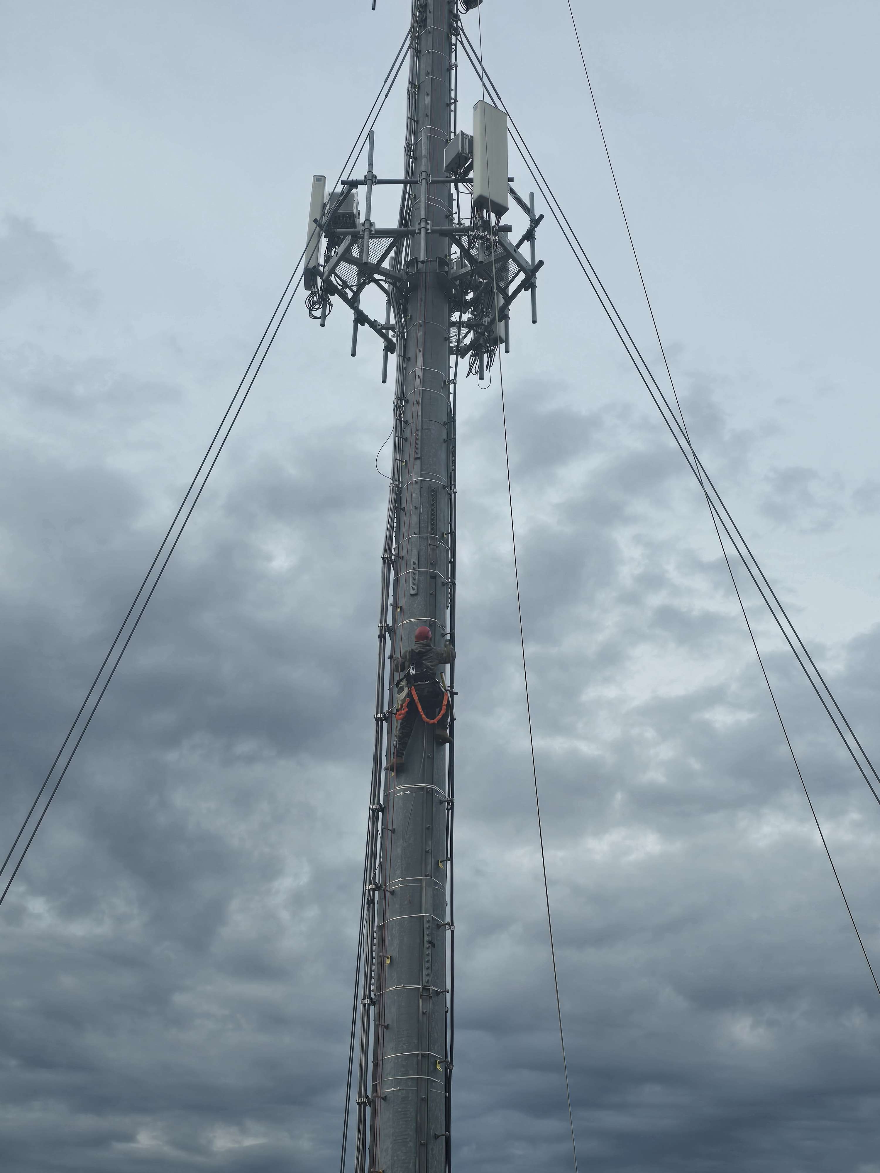Cell tower with worker climbing